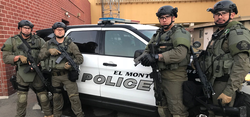 Members of the El Monte Police Department SWAT team with their police car and gear.