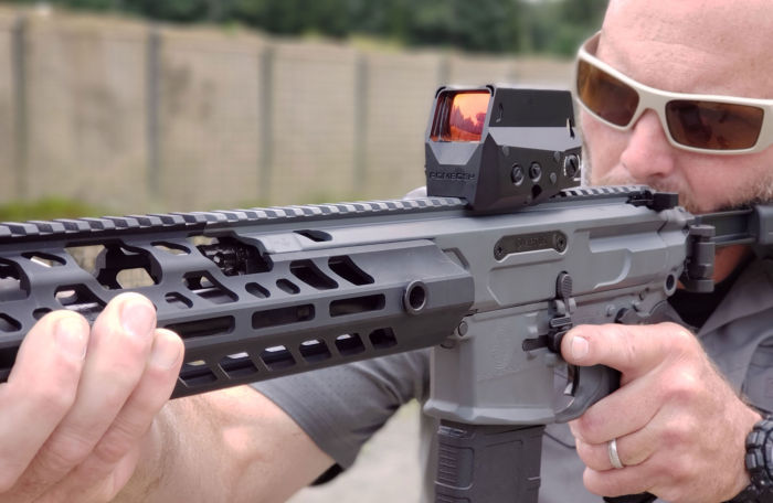 ROMEO8H red dot sight mounted on a rifle being sighted by a professional shooter