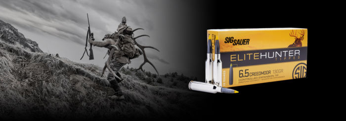 Box of Elite Hunter Tipped Ammunition with hunting themed backdrop