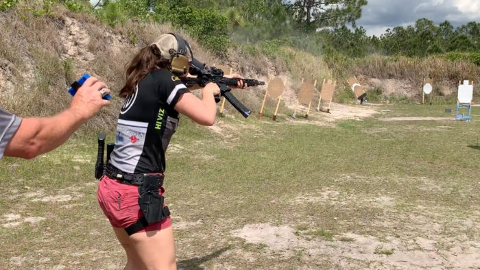 Team SIG professional shooter Lena Miculek aims a competition rifle at the USPSA